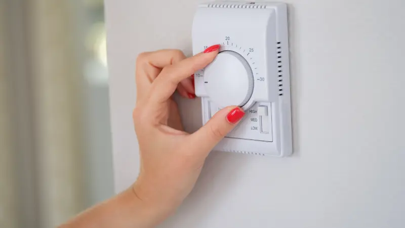 Person turning on thermostat